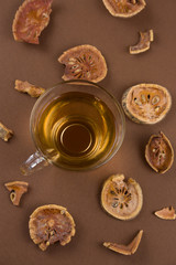 top view cup of herbal medicinal tea from dried matum on a brown background