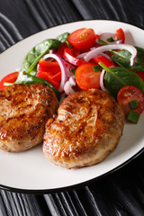 French meat balls crepinette served with fresh vegetable salad close-up. vertical