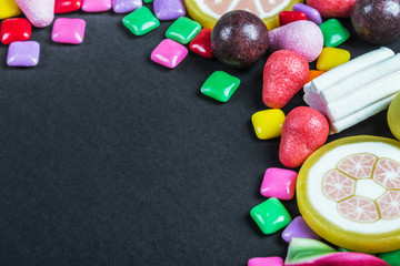 chewing gum, candy, chewing marmalade, lollipops and other sweets on black background