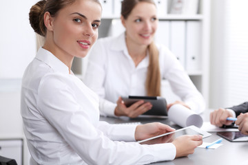 Fototapeta premium Group of business people at meeting on the background of office. Focus at a beautiful brunette woman