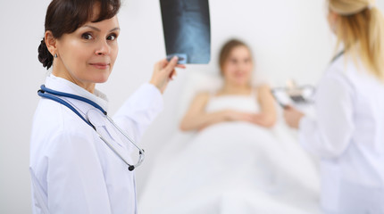 Female doctor at the background with patient. Physician at work