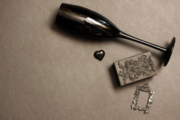 Black bird feathers, antique frame, glass heart and black rose. Gothic Valentine's Day Background....