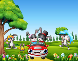 Obraz na płótnie Canvas Happy easter rabbit riding a car on the beautiful nature