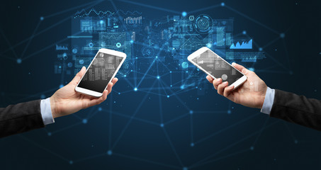 Close up of two hands holding smartphones to sync business data