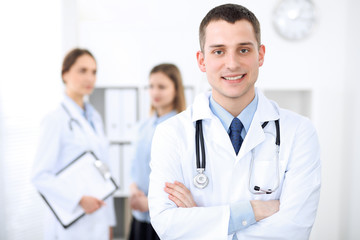 Fototapeta premium Friendly male doctor on the background of a female physician in hospital office