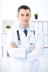 Smiling doctor waiting for his team while standing upright