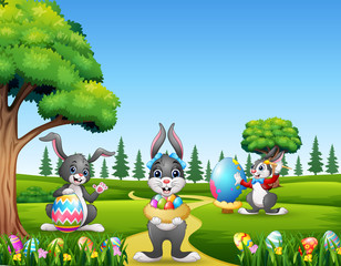 Happy easter bunnies holding and painting eggs
