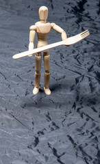 Wooden puppet on black background. Wooden mannequin.