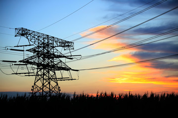 In the evening, the silhouette of high voltage towers