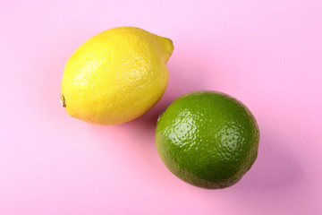 Fresh mixed exotic fruits lemon and lime on a pink background. Fruit background. Top View.