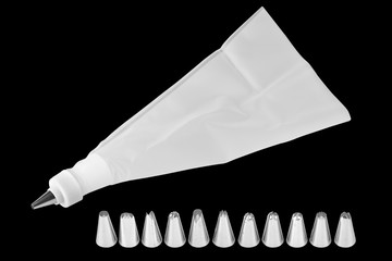 Piping bag for whipped cream frosting with several tips. Cupcake decorating tools, icing bag and nibs, isolated on black background, clipping paths included