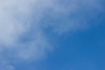 Blue sky. Blue sky with light clouds. From the blue sky it is snowing. Winter bright blue sky