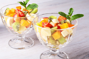 Diet-Fresh tasty mix fruit salad in the bowl on the wooden table, healthy breakfast, weight loss concept.