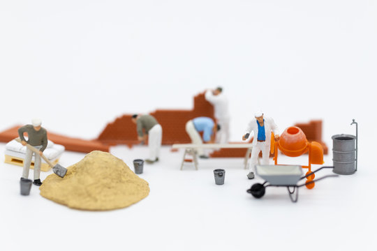 Miniature people: Construction workers building plans , have building materials, sand, brick, mortar. Use image for construction business.