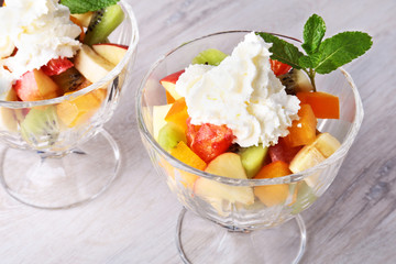Diet-Fresh tasty mix fruit salad in the bowl on the wooden table, healthy breakfast, weight loss concept.