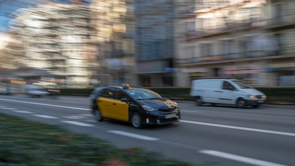 Fototapeta na wymiar Panning of a taxi cab in the street of Barcelona Spain