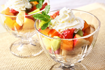 Diet-Fresh tasty mix fruit salad in the bowl on the wooden table, healthy breakfast, weight loss concept.