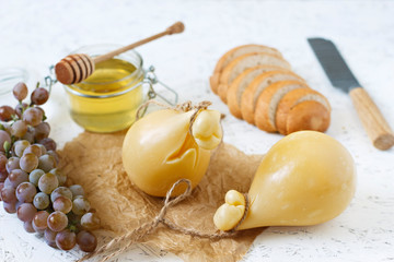 Cheese Caciocavallo wine, honey, bread on a white background. Cheese pear