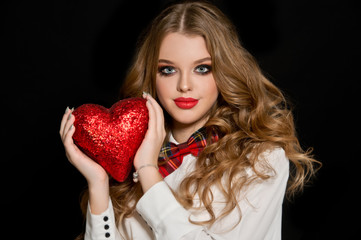 Obraz na płótnie Canvas Valentine's Day. Beautiful girl with heart. Woman with red shiny heart. 
