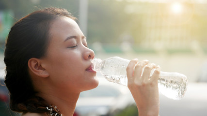 Beauty young woman drinking water in summerday