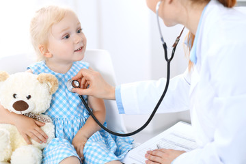 Doctor and a little blonde girl. Usual health exam. Medicine and healthcare concept