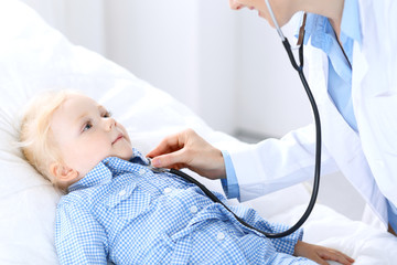Fototapeta premium Doctor and a little blonde girl. Usual health exam. Medicine and healthcare concept