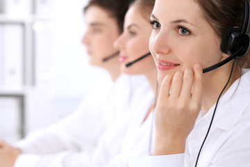Call center operators. Focus at beautiful woman in headset