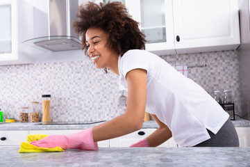 African Woman Cleaning Kitchen Counter