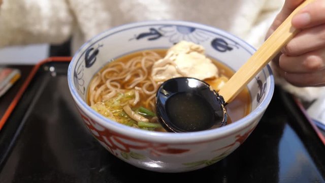 Eating hot soba noodles in broth (Kake-Soba)