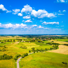Obraz premium Aerial view of a country road between agricultural fields in Europe, Germany. Beautiful landscape. Captured from above with a drone