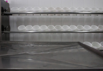 press machine for cheese molds and a metal surface with drops in a cheese factory