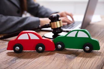 Green And Red Car In Front Of Gavel And Mallet