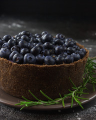 Blueberry vegan cheesecake. Dark photo on black background