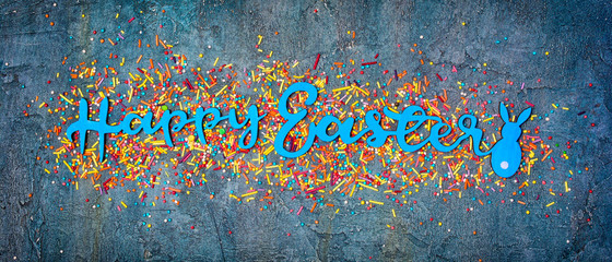 Banner with blue text of happy easter and sugar sprinkles or confetti as decor for bakery