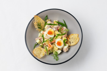 meat salad with sliced ​​quail eggs, caviar and fresh green onions, decorated with sliced ​​dried bread. Top view