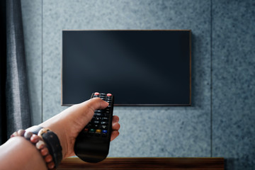 Watching Television Concept. Hand holding TV's Remote to Control or Changing Channel. Relaxation in...