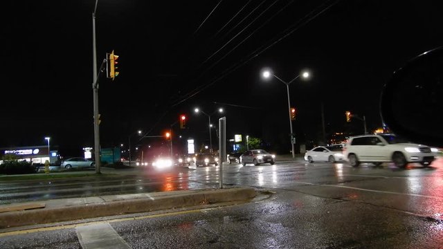 4K Street Corner At Night With Traffic And Traffic Lights On Rainy Evening