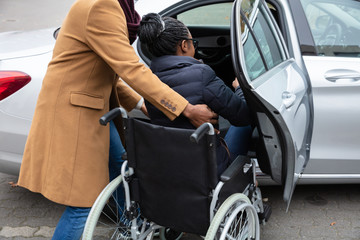 Man With Her Disabled Wife Moving Towards Car
