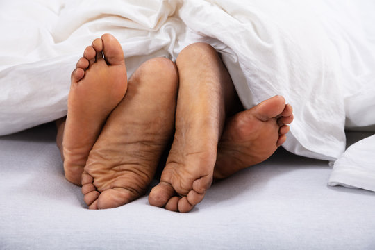 Close-up Of Couple's Bare Feet