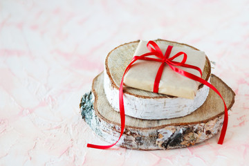 A gift with a red ribbon on a tree stand.