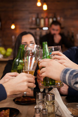 Happy young friends group making a toast about their friendship. Hipster pub.
