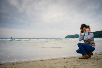 Woman walking on beach, autumn cold day