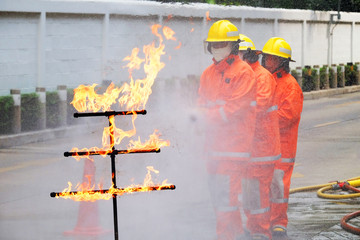 Scary fire brigade demonstrative prepared at a fire drill with background of firefighters in...