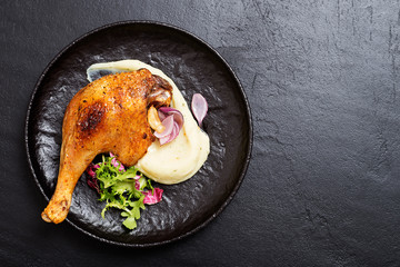 Roasted duck leg confit  with mashed potatoes and fresh salad.