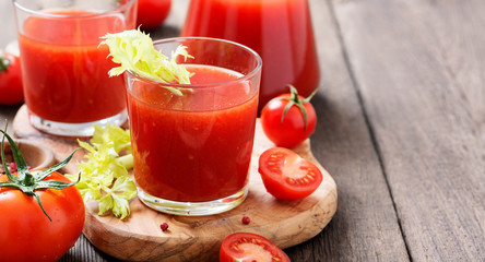 Tomato juice in glass with celery, cherry tomato  on dark background.