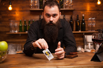 Bearded hipster bartender playing with his trick cards. having fun.