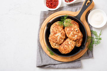 Juicy delicious meat cutlets in pan on a light gray table. Top view 