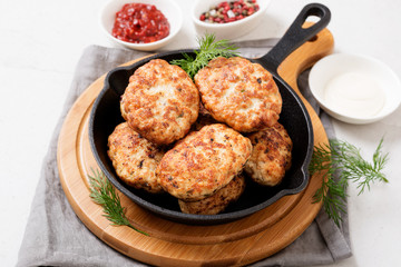 Juicy delicious meat cutlets in pan on a light gray table. 