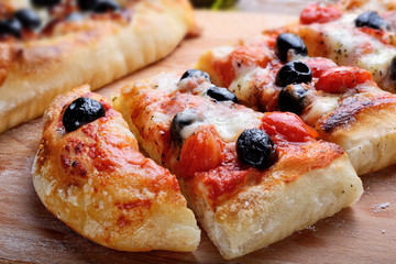 Pizza with mozzarella, tomato and black olives