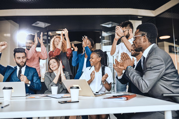 cheerful business team applauding at meeting, situation of success.happines. the growth of company.